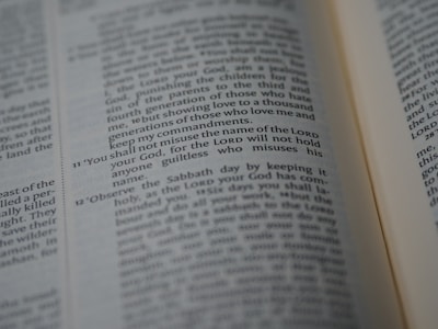 A close-up of an open Bible showing a passage with numbered verses. The focus is on verse 11, which discusses the use of the Lord's name. The text appears in two columns with a slight tilt.