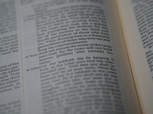 A close-up of an open Bible showing a passage with numbered verses. The focus is on verse 11, which discusses the use of the Lord's name. The text appears in two columns with a slight tilt.