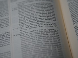A close-up of an open Bible showing a passage with numbered verses. The focus is on verse 11, which discusses the use of the Lord's name. The text appears in two columns with a slight tilt.