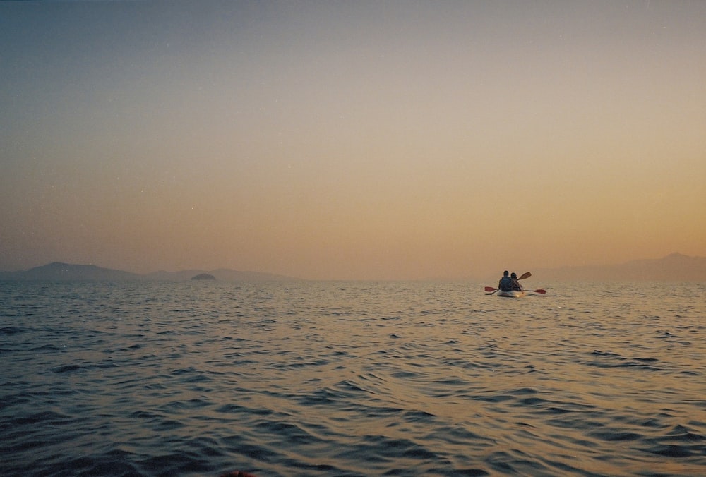 2 people in the middle of the sea during daytime