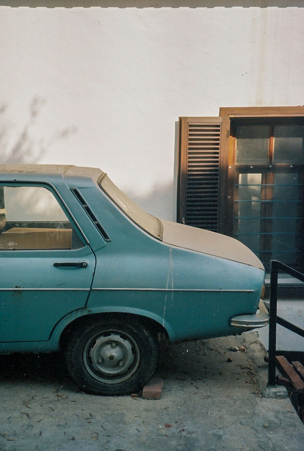 teal car parked near building