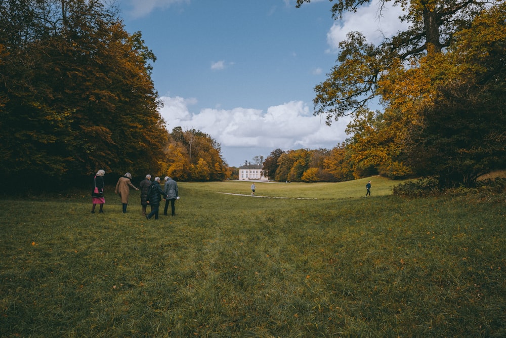 people standing on green grass field during daytime