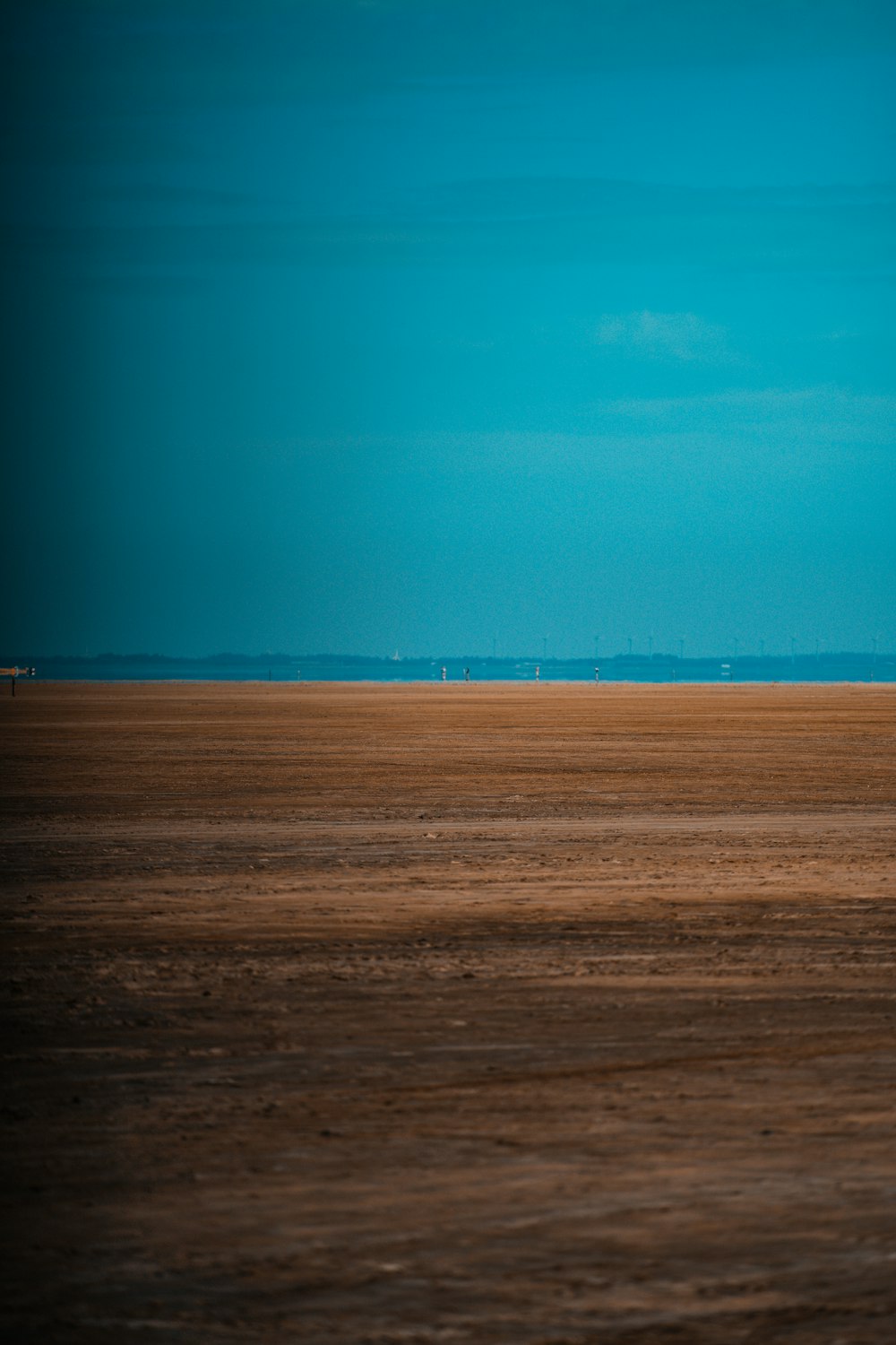 Campo marrón bajo el cielo azul durante el día