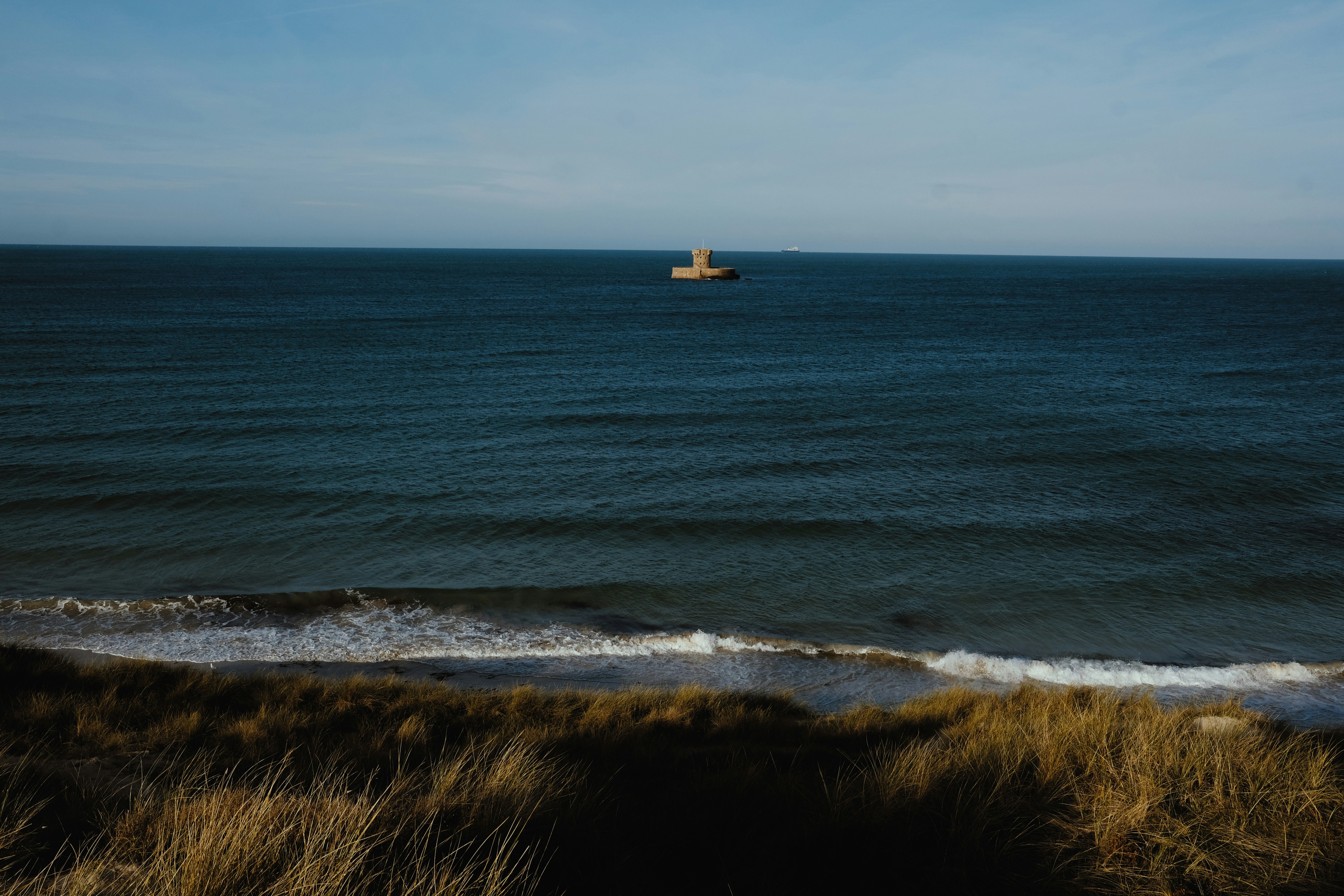 Brown and white lighthouse near body of water during daytime photo ...