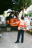 man in orange and white stripe polo shirt and black pants standing beside orange and black