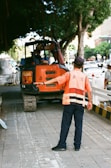 man in orange and white stripe polo shirt and black pants standing beside orange and black