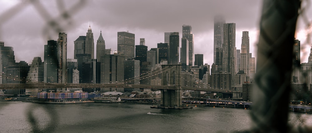 bridge over river near city buildings during daytime