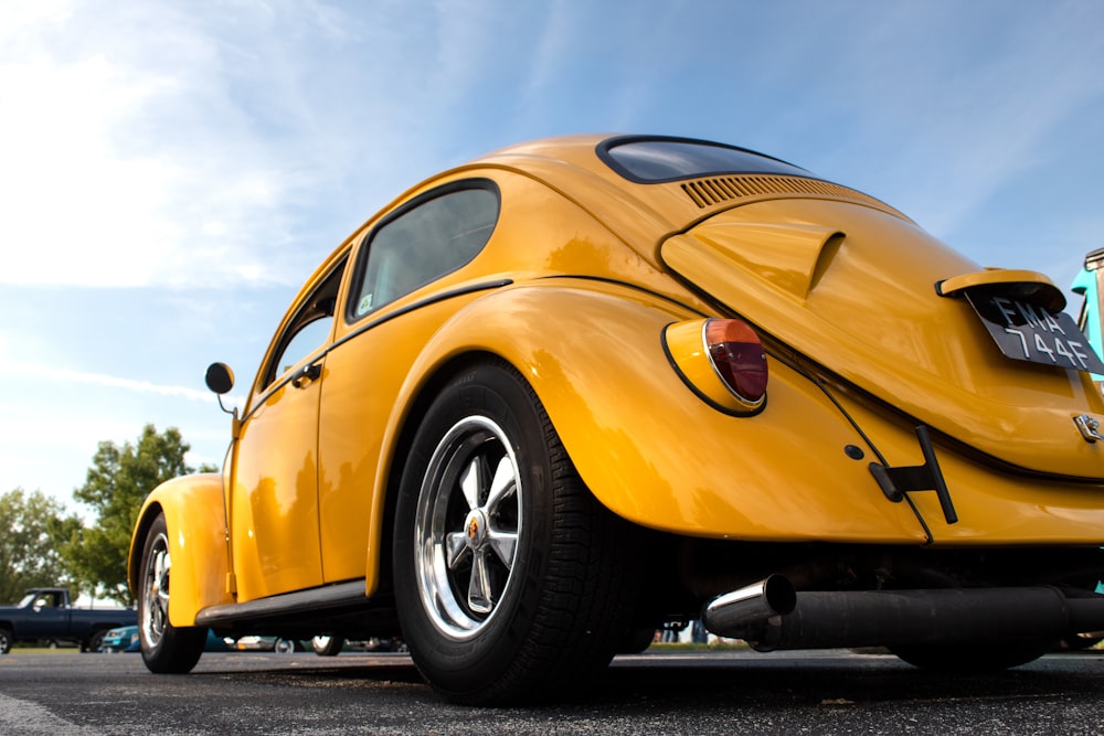 yellow porsche 911 parked on black asphalt road during daytime