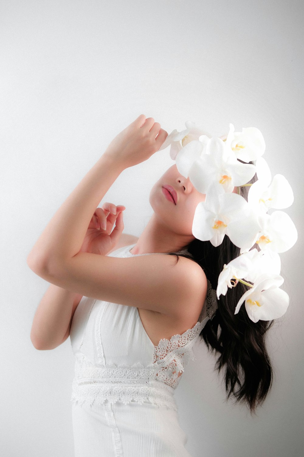 woman in white floral dress holding white flower