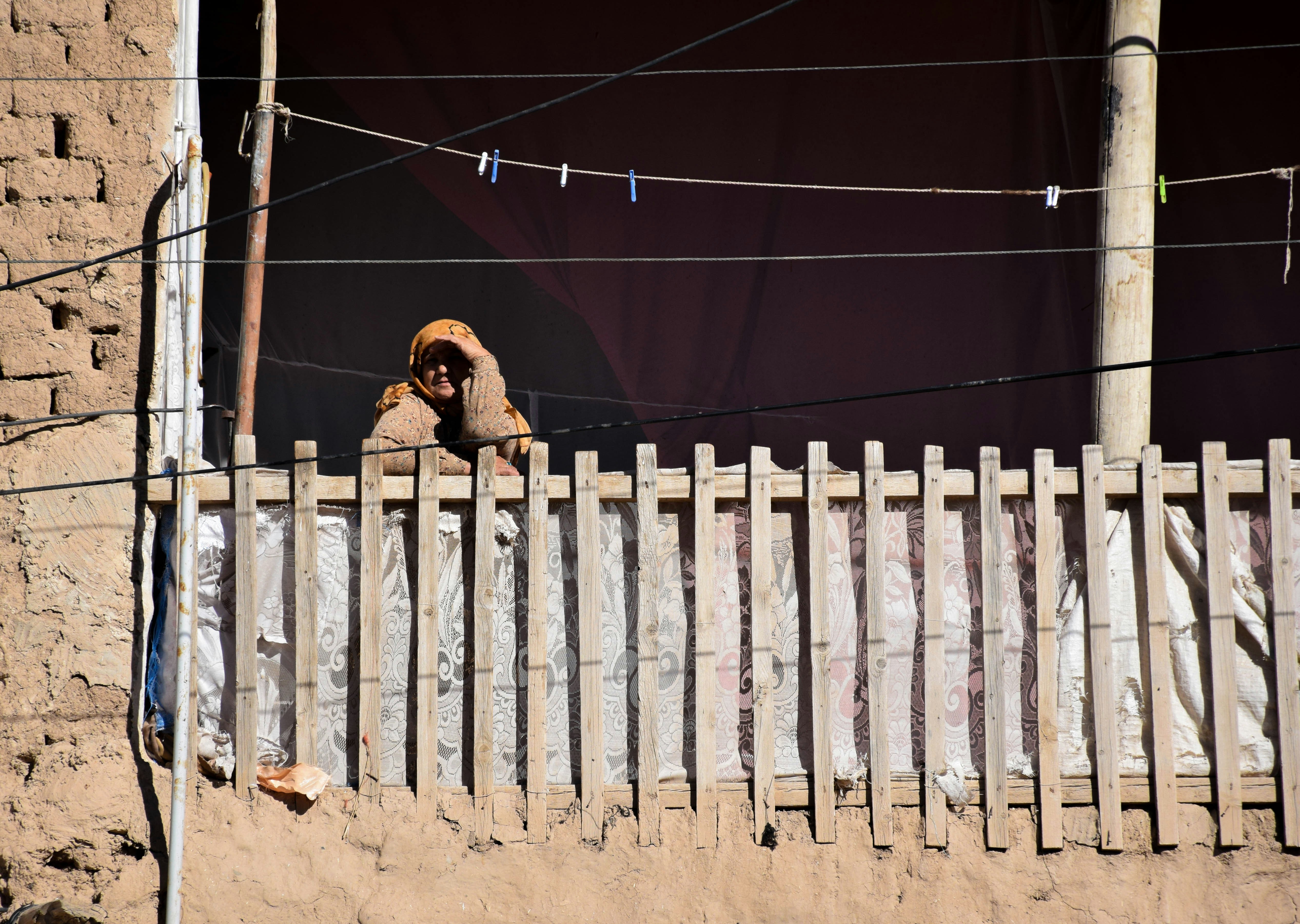 Frau in brauner Jacke steht nachts auf braunem Sand