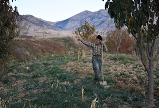 An elderly man receiving assistance from a volunteer in a rural area.