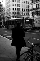 Model walking through a bustling city street wearing a sharp, tailored coat.
