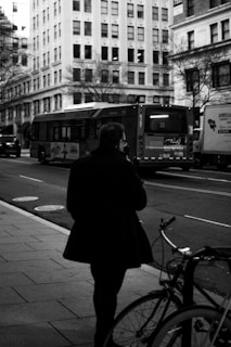 Model walking through a bustling city street wearing a sharp, tailored coat.