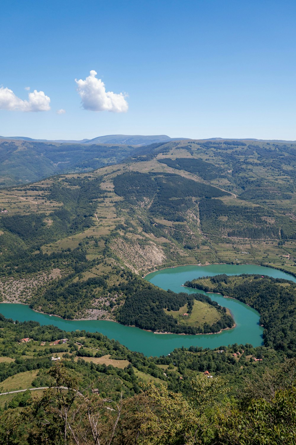 aerial view of green mountains and lake