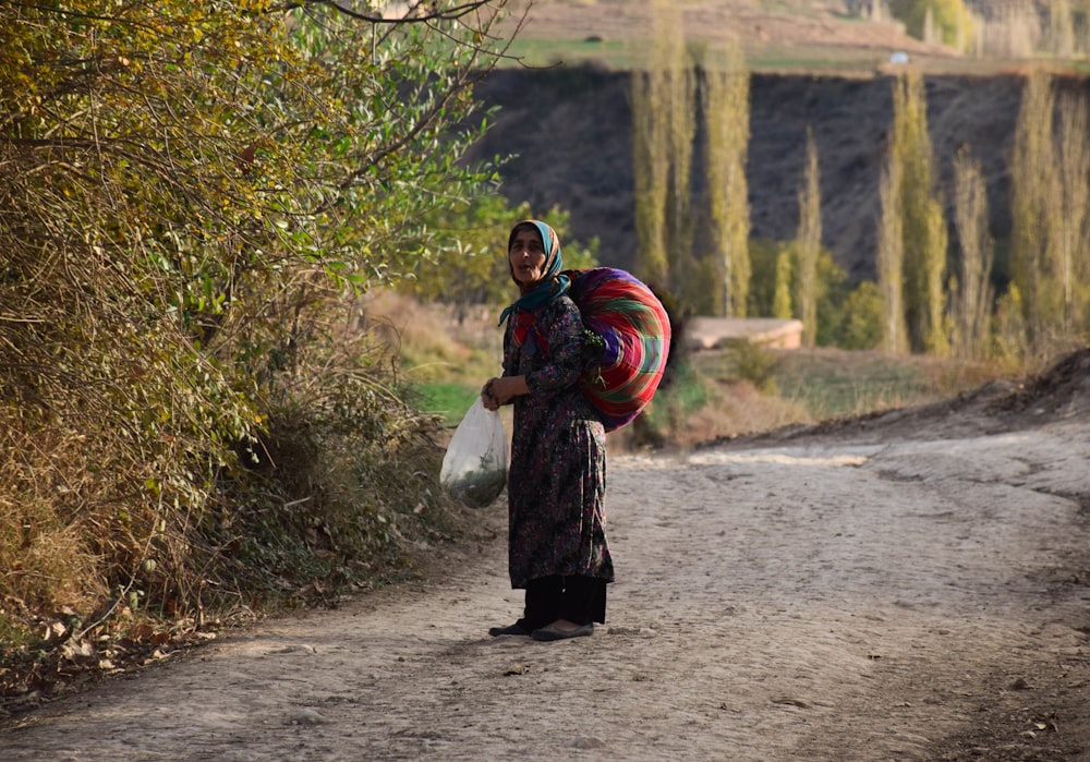 woman in black coat holding red and blue scarf