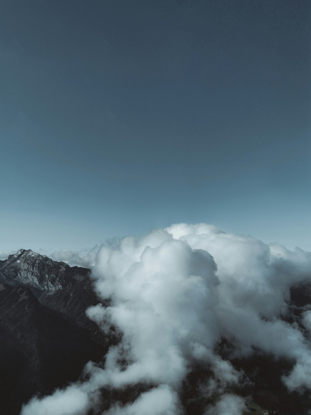 white clouds on blue sky over gray mountain