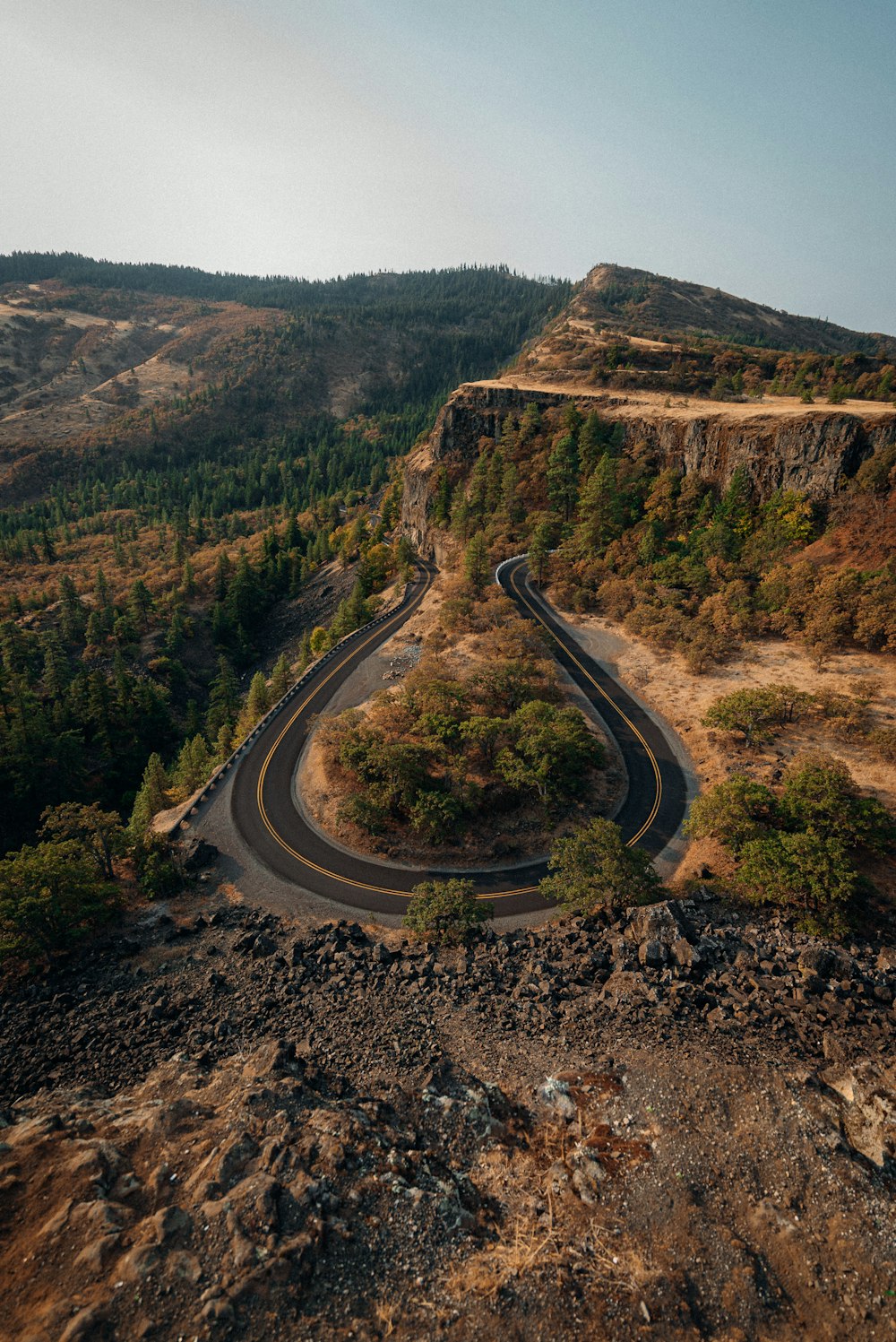 aerial view of road in the middle of brown mountains