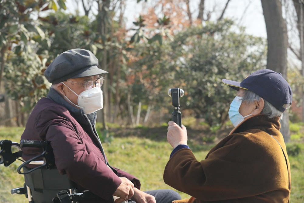 man in brown jacket and white helmet holding black and silver camera during daytime