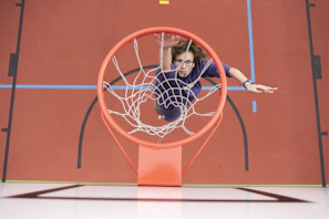 Dynamic shot of a basketball player mid-air dunk with neon blue lighting accents.