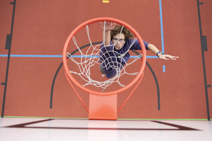 Dynamic basketball player in action wearing official Olympico gear on a vibrant court