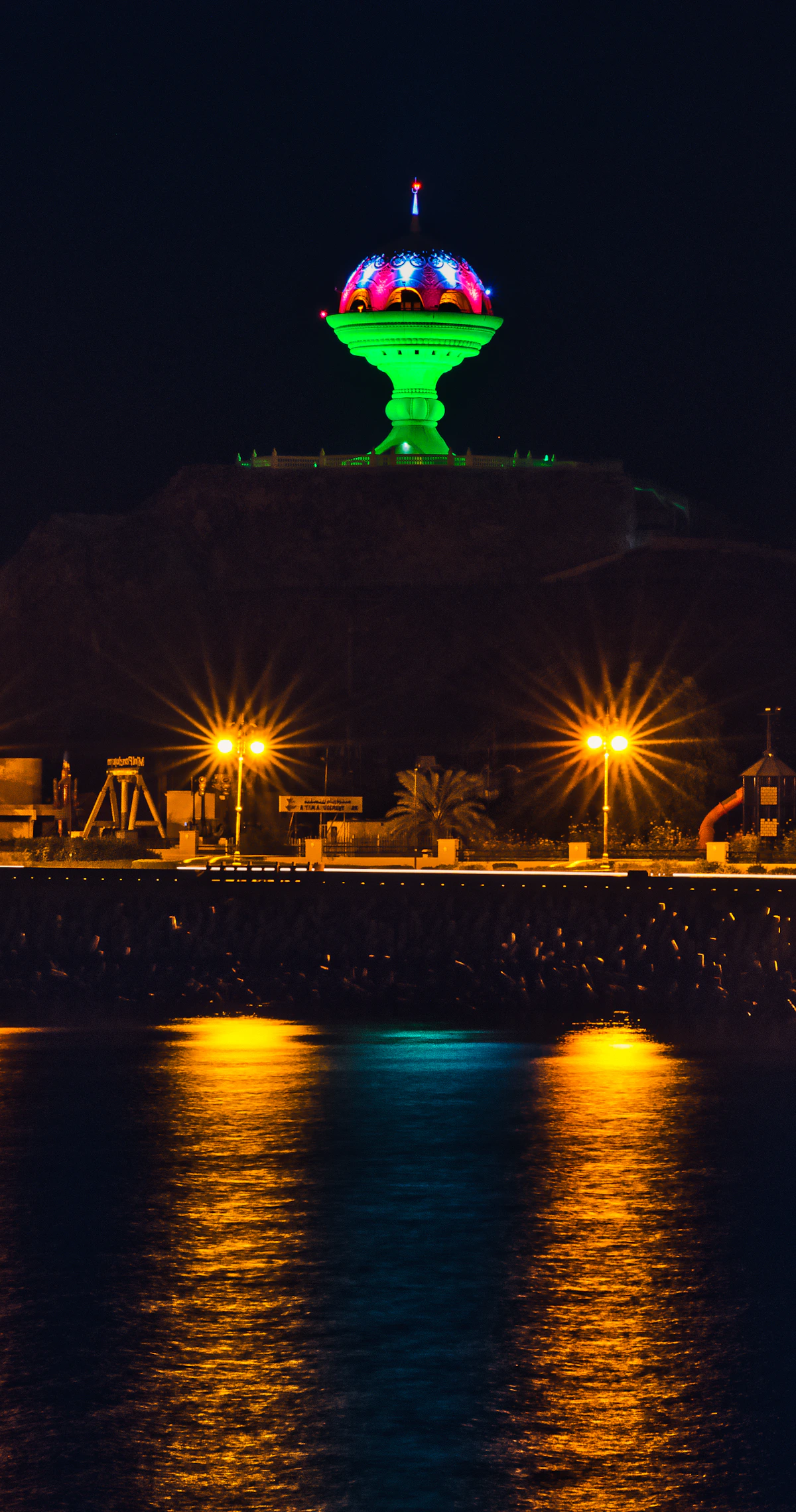 The illuminated Riyam incense burner monument above Muscat's coast at night