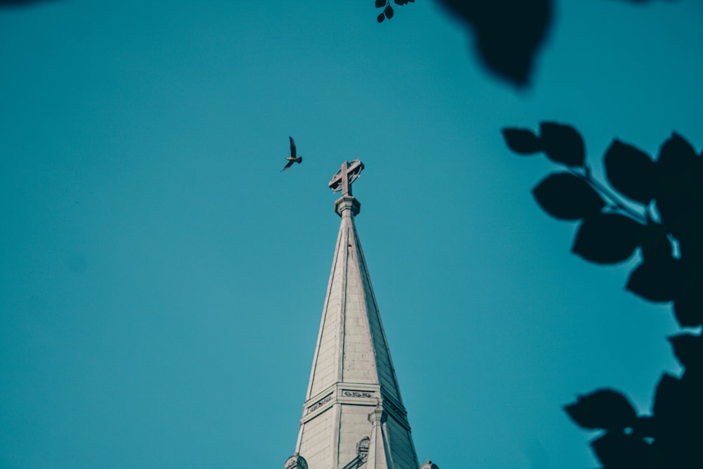 low angle photography of gray concrete tower under blue sky during daytime