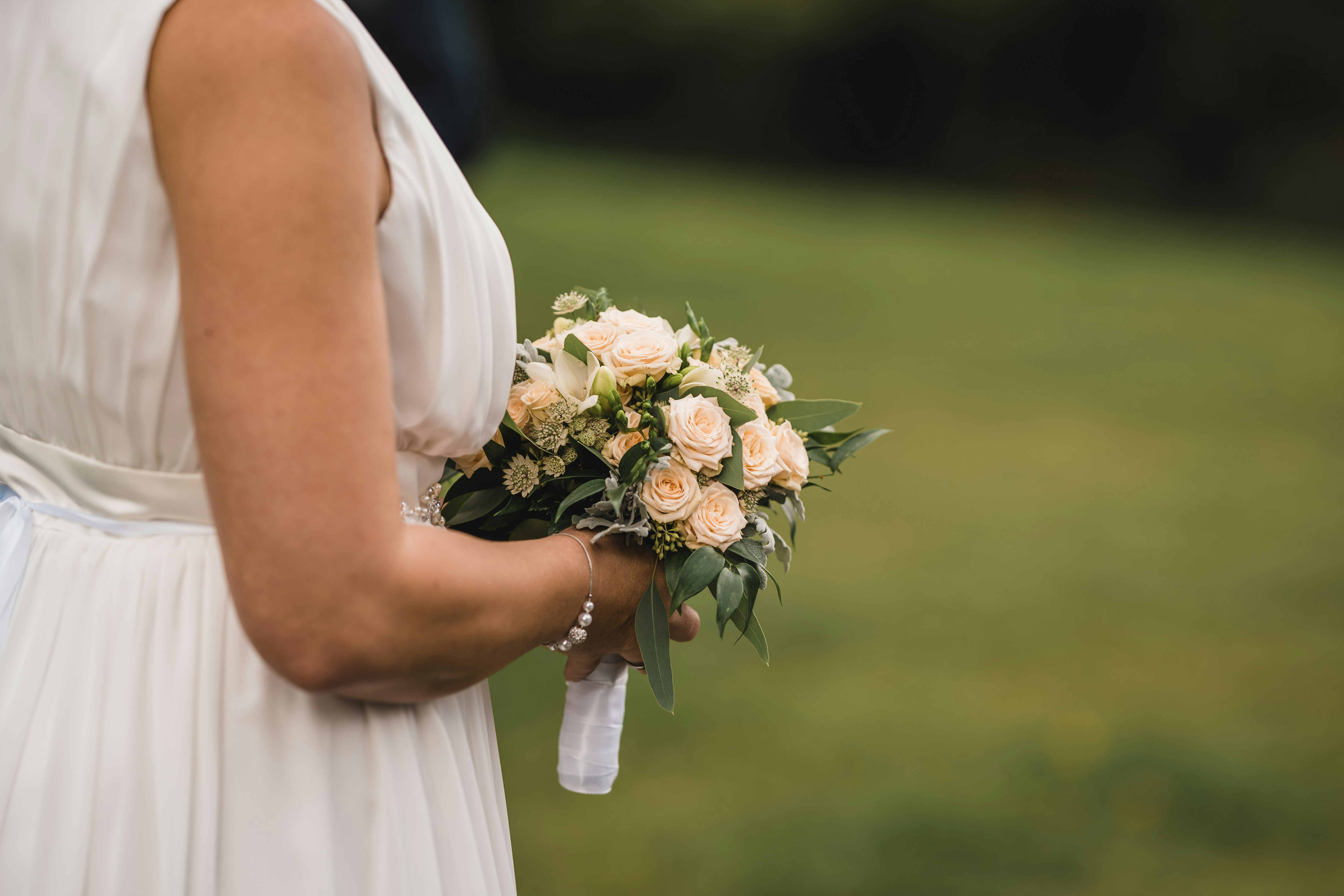 woman in white wedding dress holding bouquet of flowers