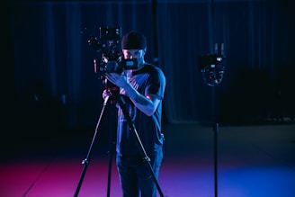 man in white t-shirt holding black dslr camera
