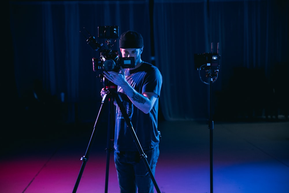 man in white t-shirt holding black dslr camera