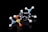 A molecular model composed of various colored spheres connected by rods, representing atoms and bonds. The model is placed against a black background, highlighting the vibrant colors of the spheres including blue, yellow, orange, and white.