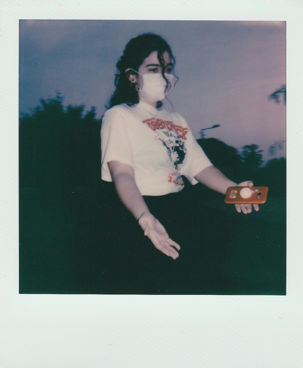 woman in white t-shirt holding brown wooden cup