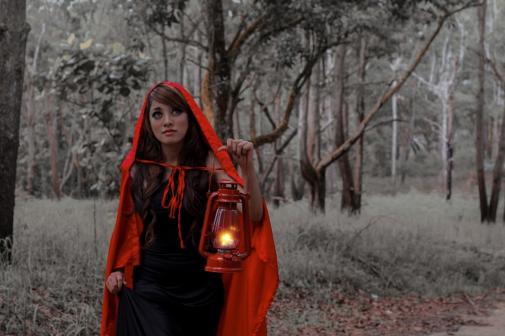 woman in red hijab standing on forest during daytime