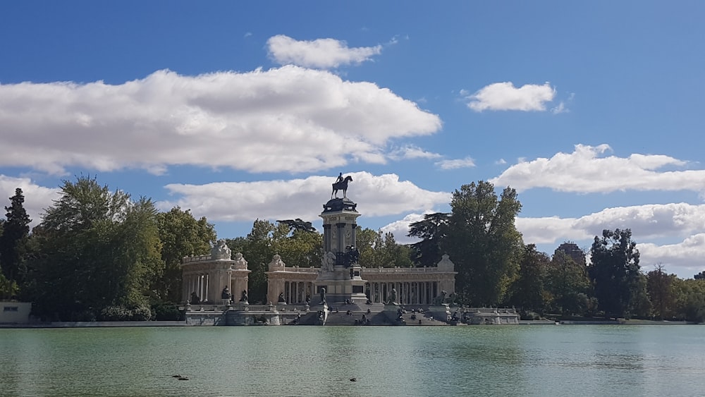 gray concrete building near body of water under blue sky during daytime