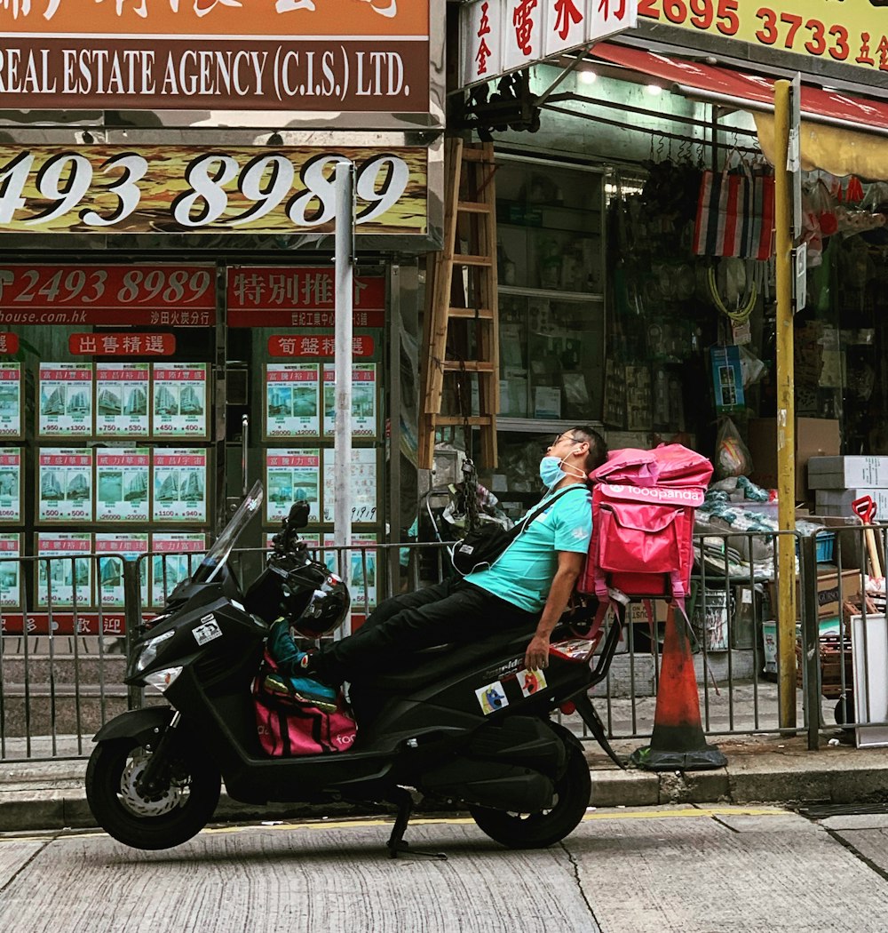 Frau in rosa Jacke fährt auf schwarzem Motorrad