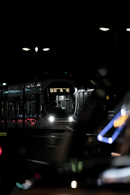 Night view of a tram system illuminated by subtle blue and steel gray lighting.