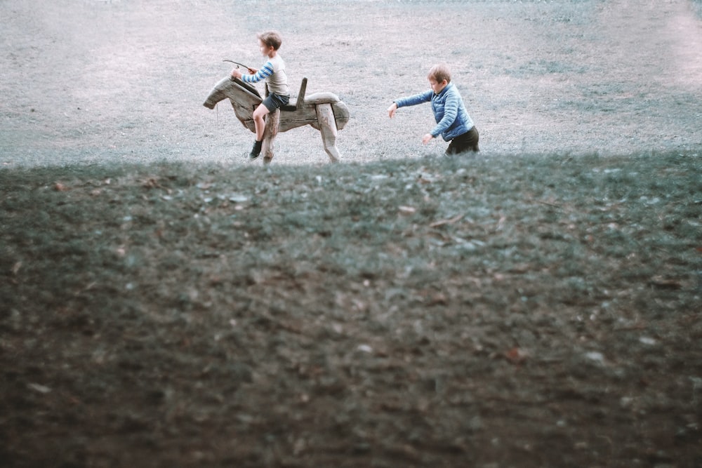 2 boys running on field during daytime