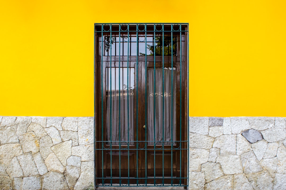 grey metal door on yellow painted wall