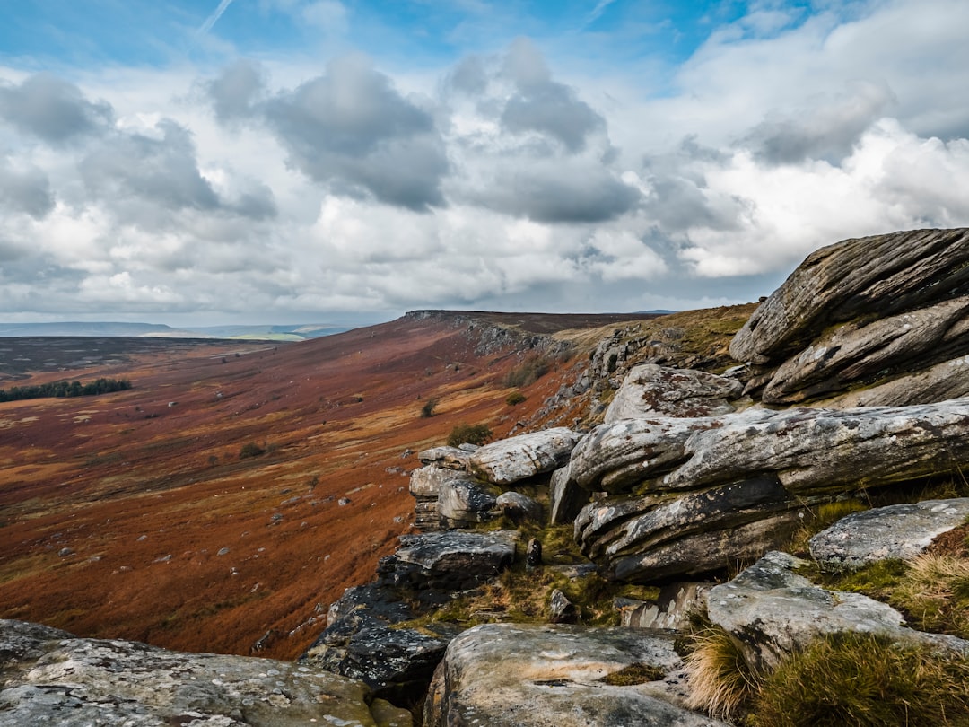 brown and gray rocky mountain under white clouds and blue sky during daytime