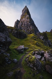 Film production services: green grass field near a rocky mountain during the daytime