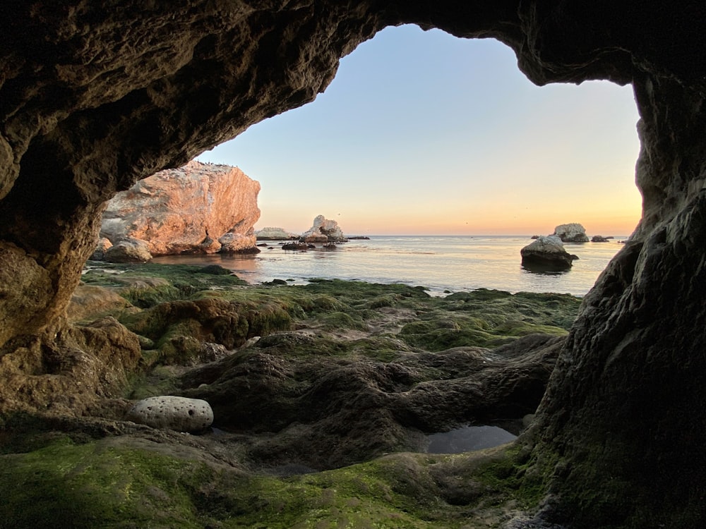 formação rochosa marrom no mar durante o dia