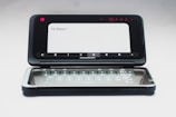A dual-screen smartphone with one screen displaying a message saying 'Hi there!' and the second screen showing a virtual keyboard. The device is in an open position, and the background is neutral, enhancing the focus on the smartphone.