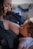 A tender moment between a mother and her baby as she breastfeeds. The mother is wearing a denim shirt and is smiling as she gazes at the baby, who is wrapped in white clothing and looking up at her.