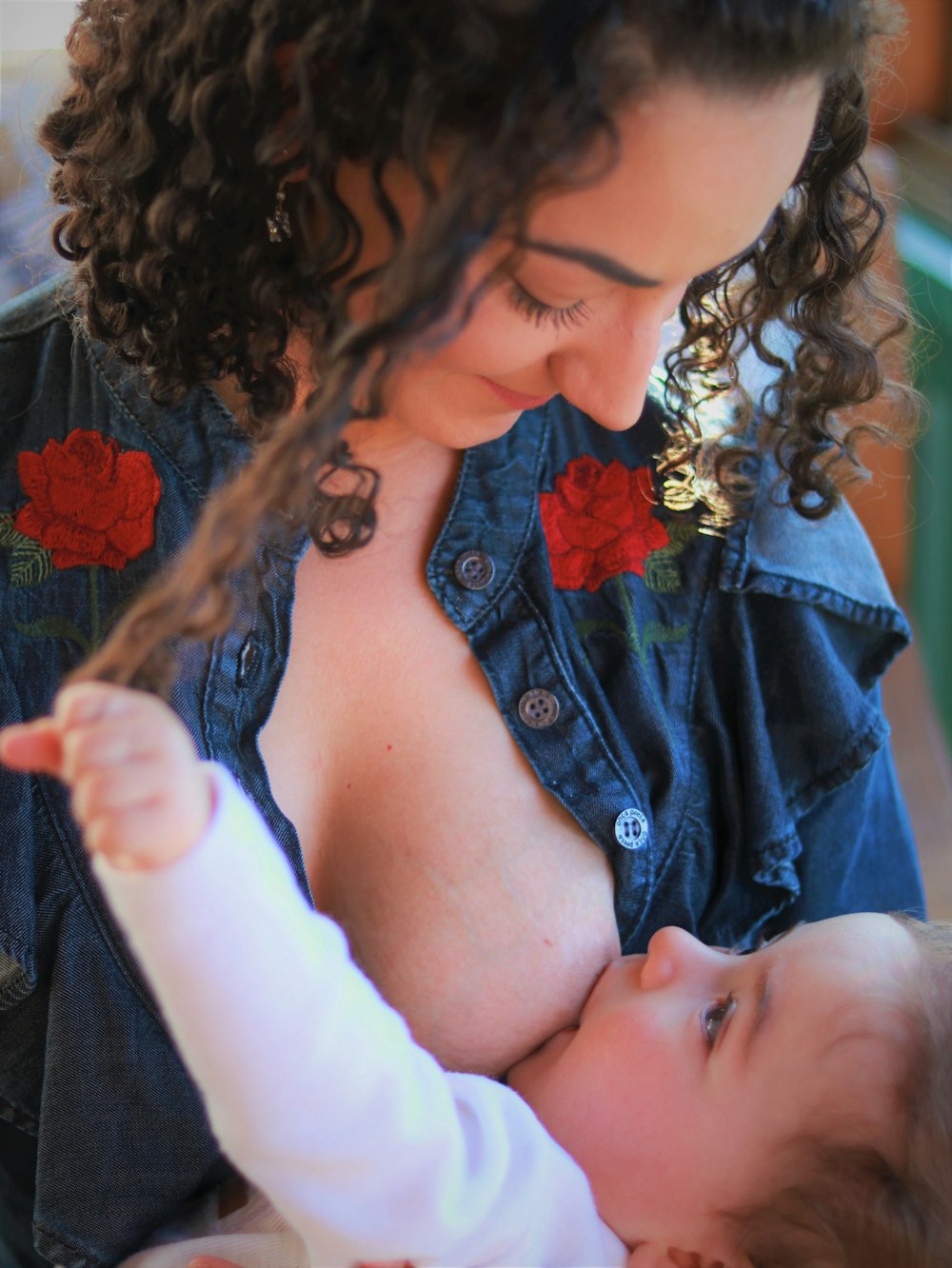 woman in blue denim jacket holding baby