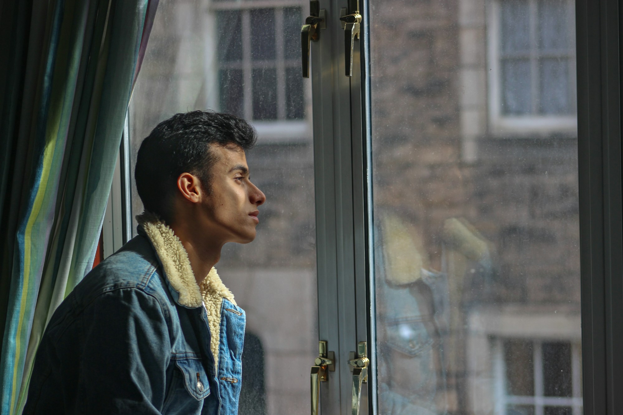 Man standing alone looking out a window