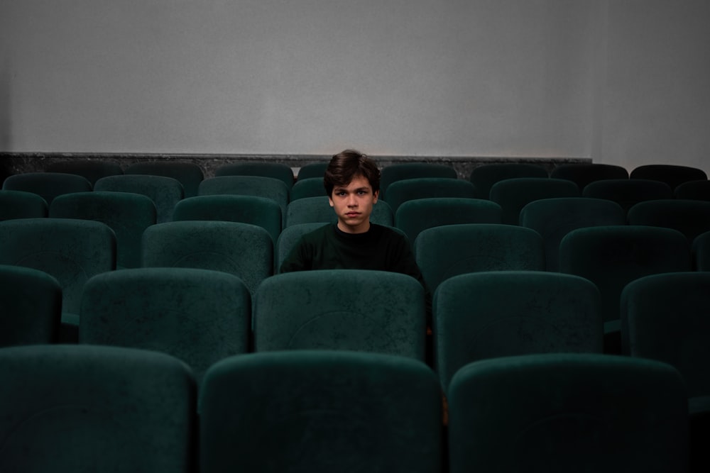 boy in blue shirt sitting on blue chair