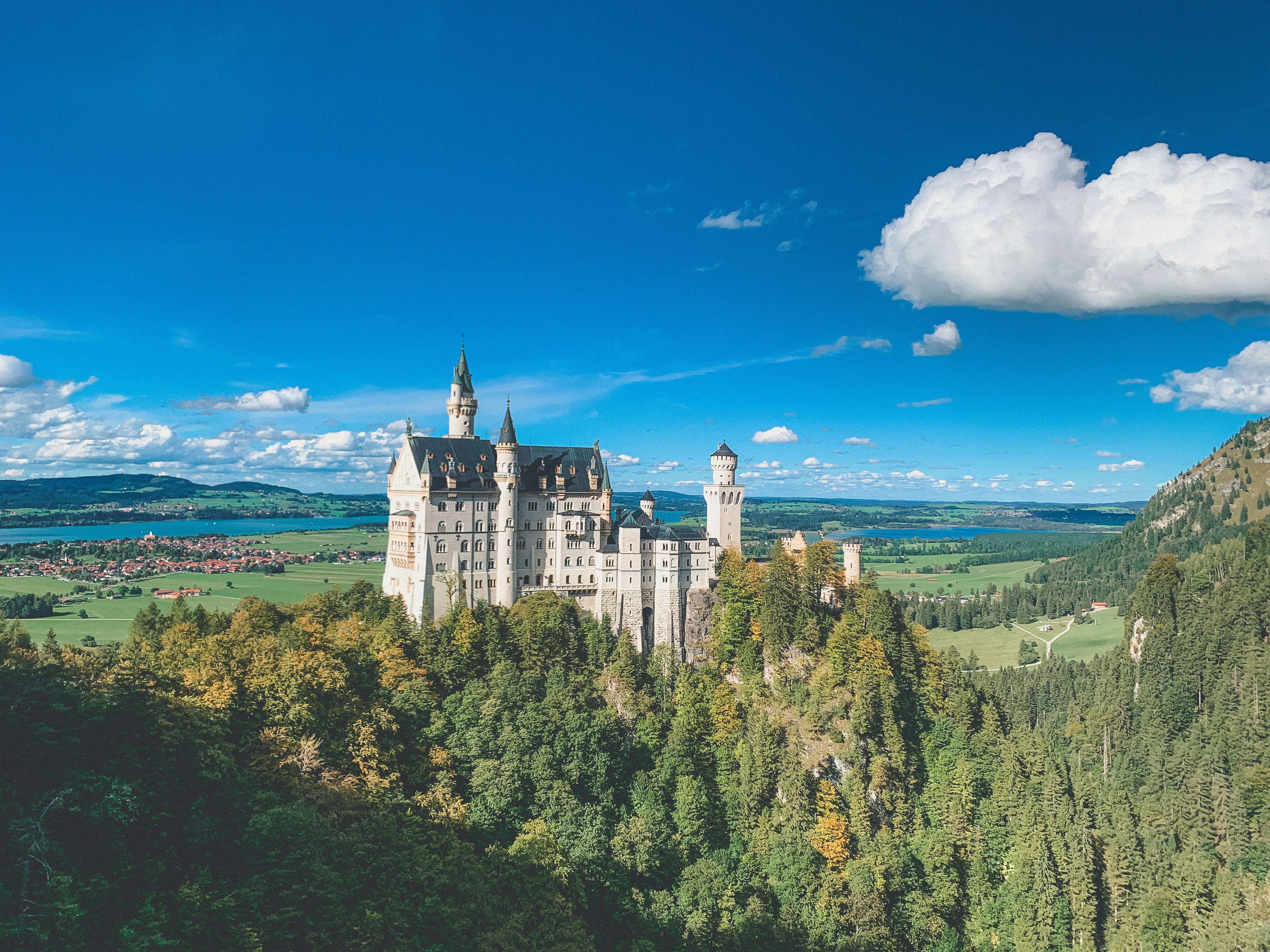 white and gray castle on top of hill under blue sky during daytime, 