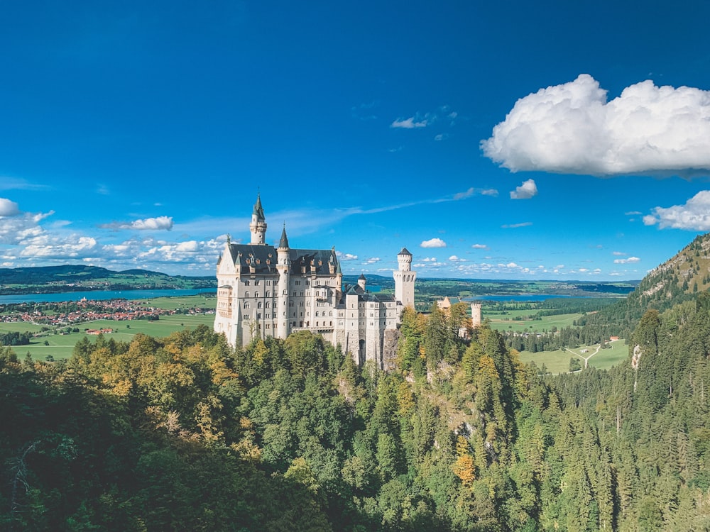 white and gray castle on top of hill under blue sky during daytime