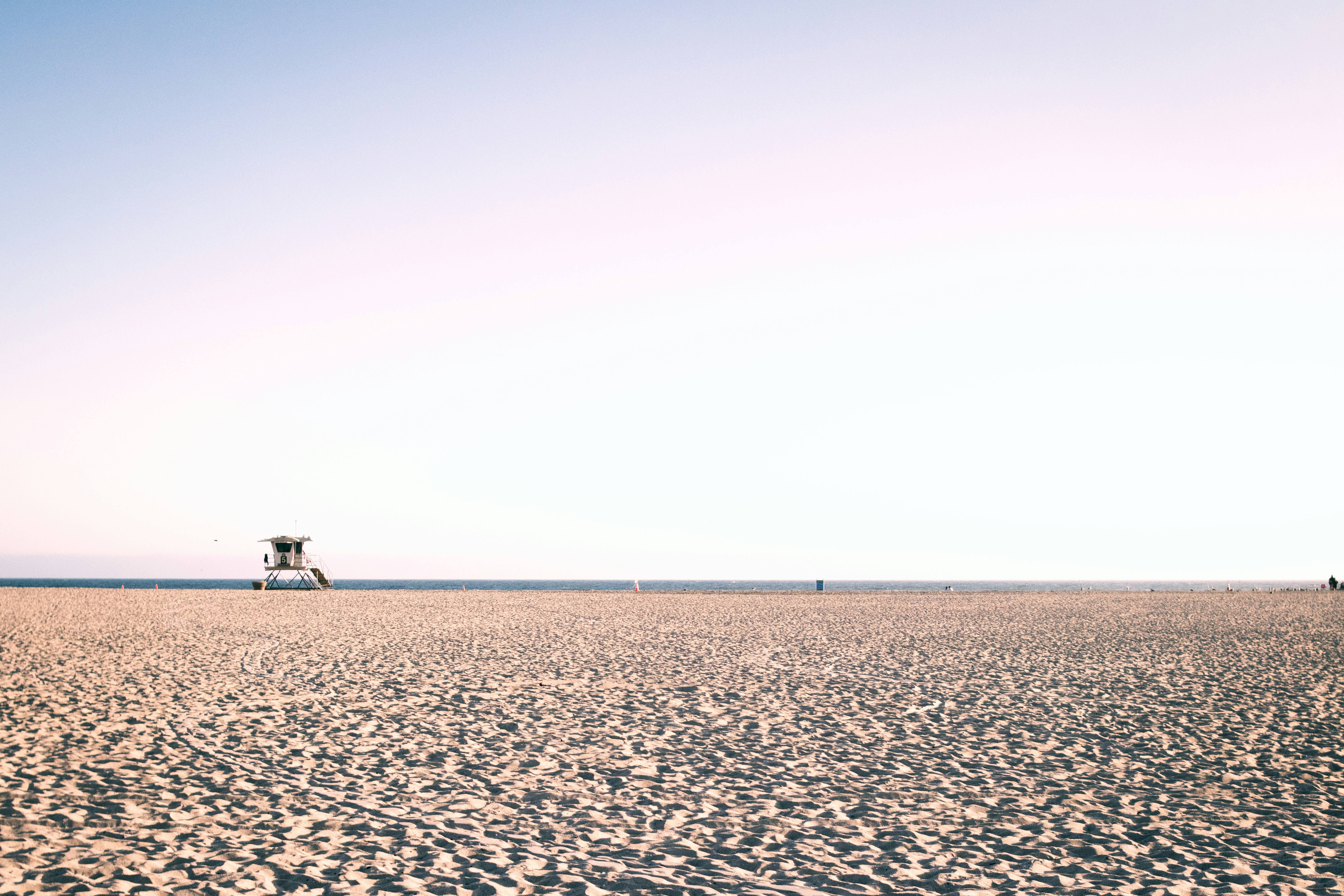 Menschen, die tagsüber auf braunem Sand spazieren gehen