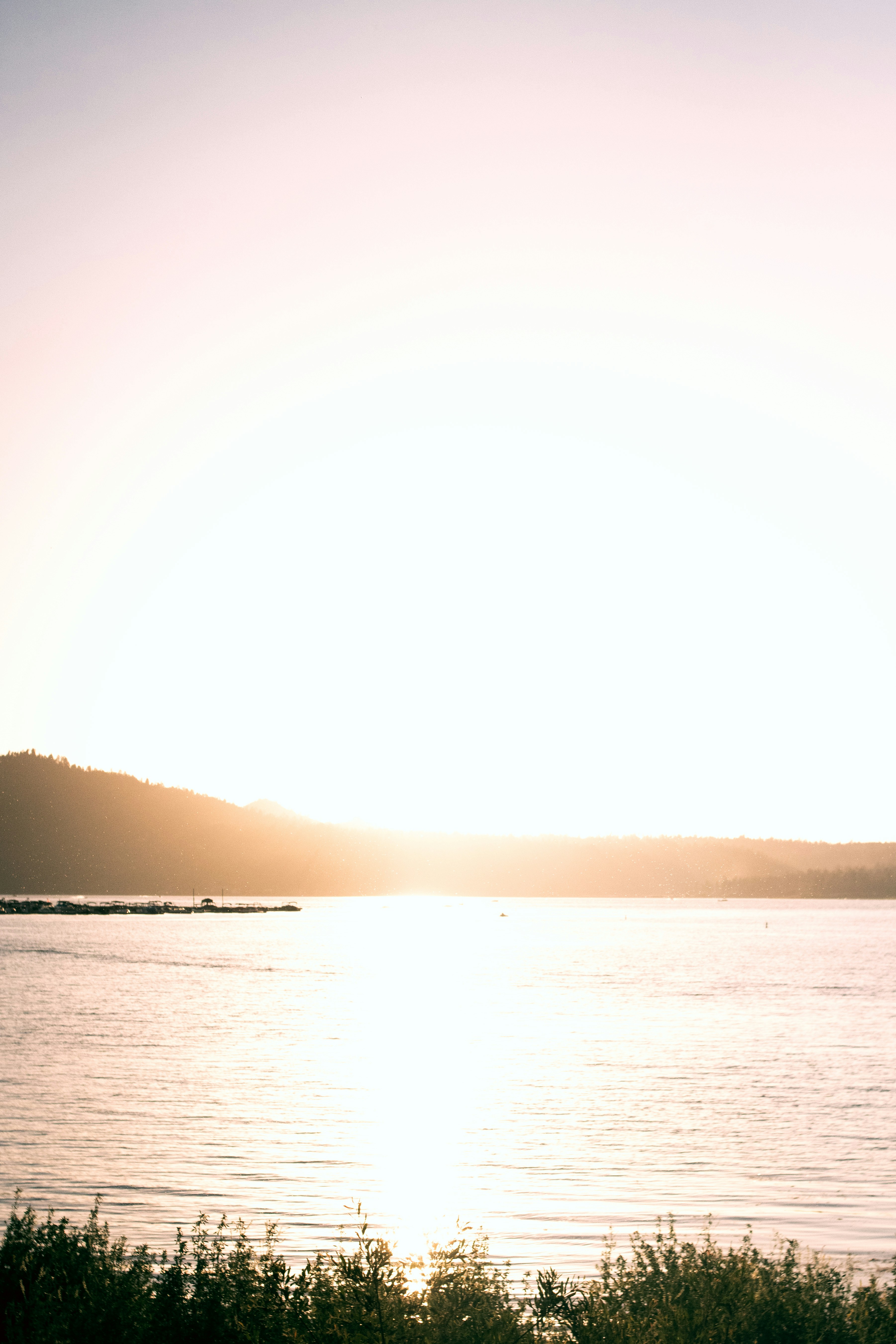 Silhouette der Person, die tagsüber am Meeresufer steht