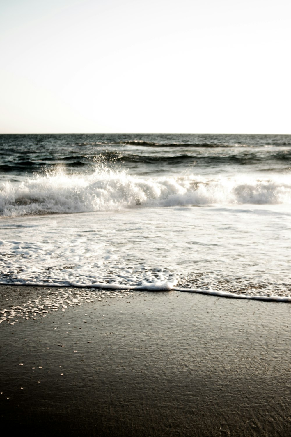 ocean waves crashing on shore during daytime